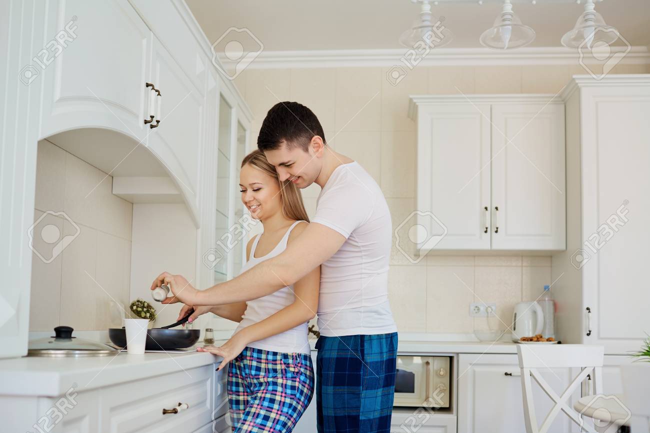 97398447-una-pareja-en-pijama-está-cocinando-comida-en-la-cocina.jpg
